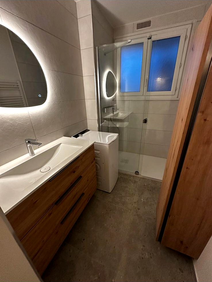 Salle de bain avec meuble vasque suspendu en bois et miroir rétroéclairé